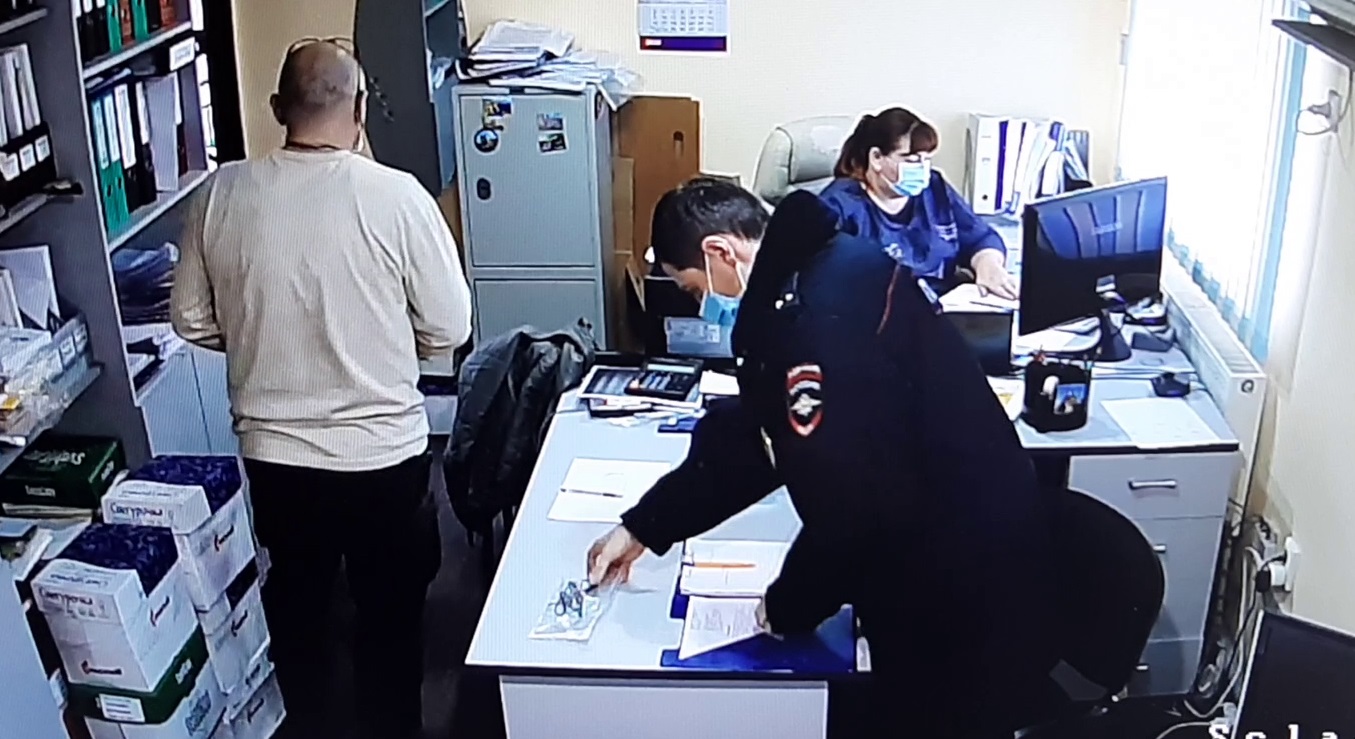 Клинников Д.А. берет вещдок очки  со стола 